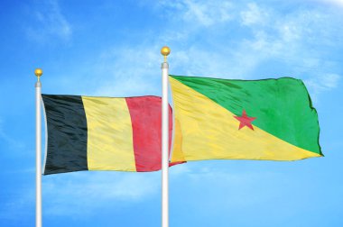 Belçika ve Fransız Guyanası bayrak direkleri ve mavi bulutlu arka planda iki bayrak