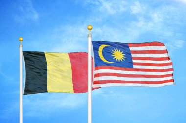 Belçika ve Malezya bayrak direkleri ve mavi bulutlu arka planda iki bayrak