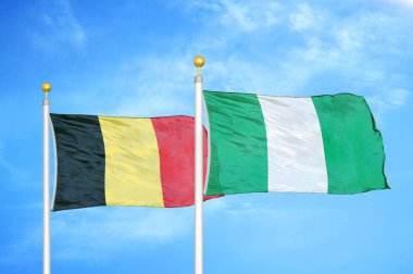 Belçika ve Nijerya bayrak direkleri ve mavi bulutlu arka planda iki bayrak