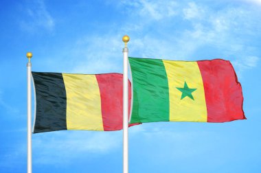 Belçika ve Senegal bayrak direkleri ve mavi bulutlu arka planda iki bayrak