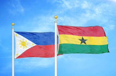 Filipinler ve Gana bayrak direkleri ve mavi bulutlu arka planda iki bayrak