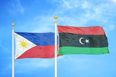 Filipinler ve Libya bayrak direkleri ve mavi bulutlu arka planda iki bayrak