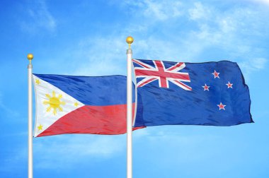 Filipinler ve Yeni Zelanda bayrak direkleri ve mavi bulutlu arka planda iki bayrak