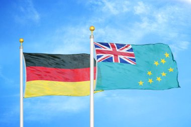 Almanya ve Tuvalu bayrak direkleri ve mavi bulutlu arka planda iki bayrak
