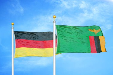 Almanya ve Zambiya bayrak direkleri üzerinde iki bayrak ve mavi bulutlu arka plan
