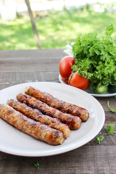 Kömürlerin üzerinde ızgara sosis