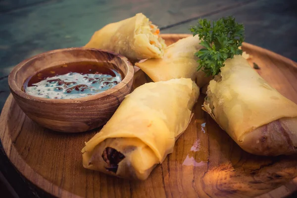 Asya yemekleri ahşap tabakta yuvarlanıyor.