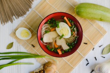 Yumurta ve erişte bambu substrat üzerine Japon çorbası. Yeşil soğan, yumurta, zencefil, sarımsak, defne yaprağı.