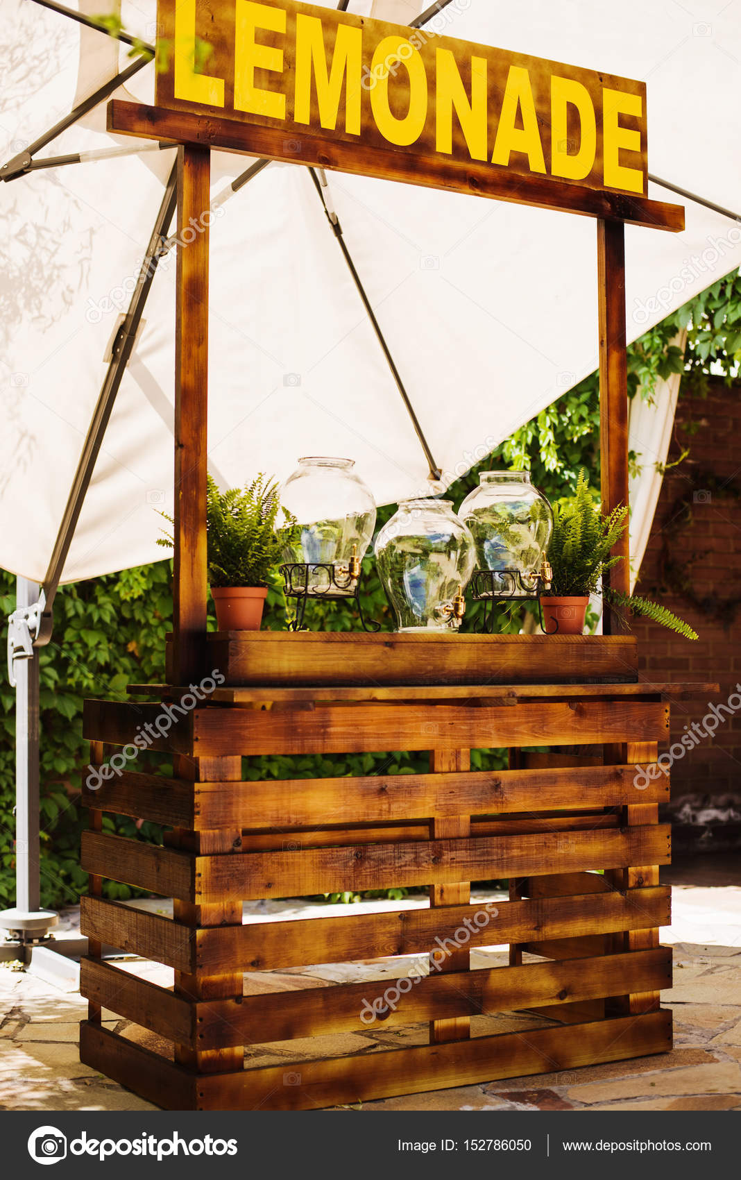 Holzvitrine mit Limonade, weicher Napisami unter einem Sonnenschirm im