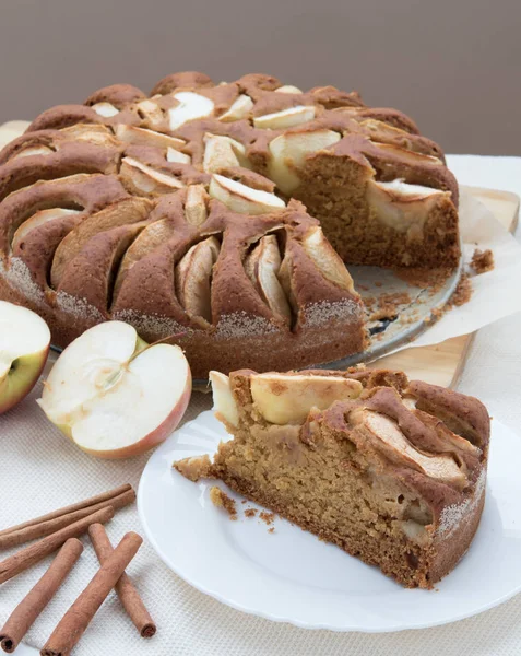 Vegetariánské jablečný dort na stůl s apple vyjmout a tyčinky skořice — Stock fotografie