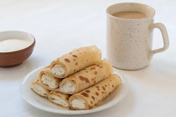 Rolos de panqueca com queijo cottage na placa branca . — Fotografia de Stock