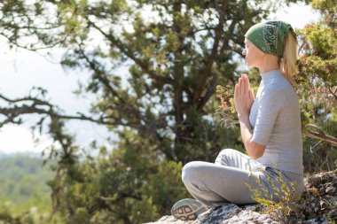 Lotus poz dağın tepesinde oturan yoga kadın. Yoga kavramı.