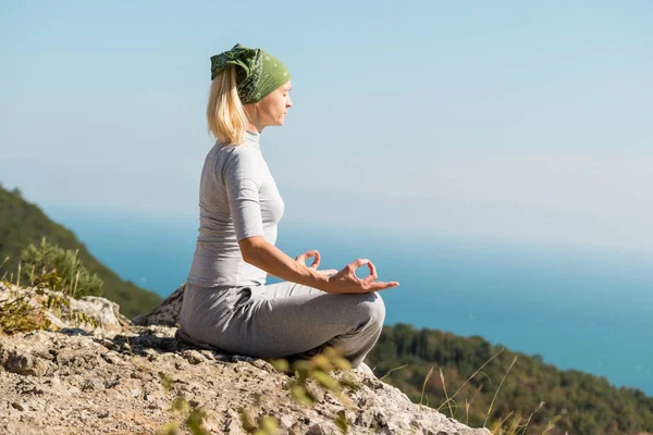 Yoga Woman is sitting on the top of the mountain and meditates.  Yoga concept. — Stock Photo, Image