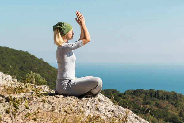 Yoga Donna seduta sulla cima della montagna in posa loto. Concetto yoga . Foto Stock Royalty Free