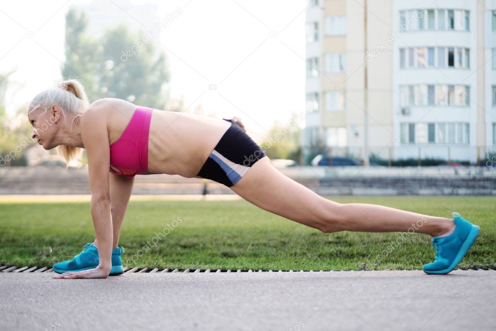 Sports runner women is stretching her legs 