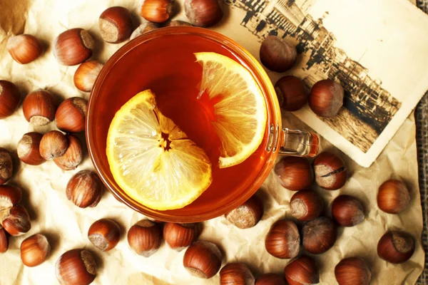 Bir bardak limonlu siyah sıcak çay, fındık retro bir kart ile bej bir kağıt üzerinde