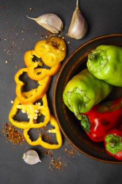 Plaka tatlı Bulgar biber ve baharat ve gri bir arka plan üzerine sarımsak doğranmış biber ile