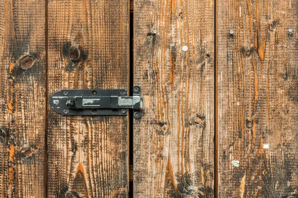 Picture of old brown colored wooden door locked with a padlock — Stock Photo, Image