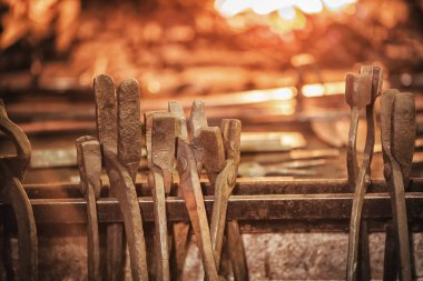 Yanan kömürleri, aletleri ve parlayan metal işçiliği olan demirci ocağı..