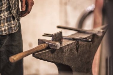 Yanan kömürleri, aletleri ve parlayan metal işçiliği olan demirci ocağı..