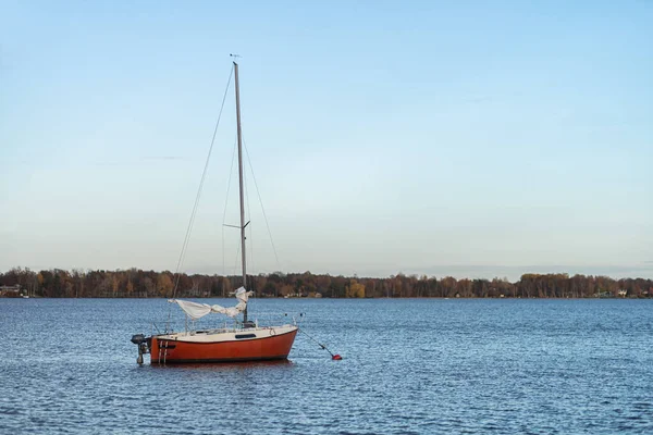 Zdjęcie czerwonej drewnianej łodzi na jesiennym jeziorze — Zdjęcie stockowe