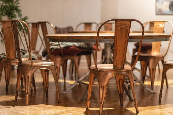 Stylové měděné židle s dřevěným stolem — Stock fotografie