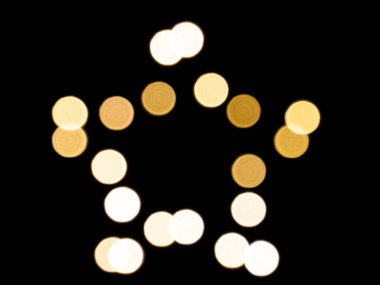 Siyah arkaplanda yıldız şeklindeki ışığın odaksız görüntüsü