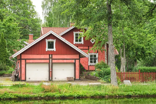 Casa tradicional scnadinavian de madera roja con un garaje frente a ella — Foto de Stock