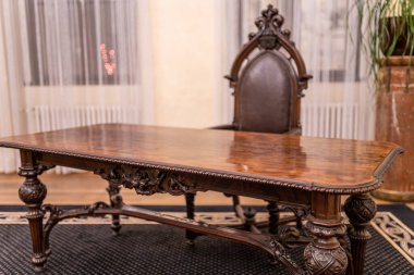 Deri koltukları ve eski ahşap masası olan eski çalışma odasının resmi.