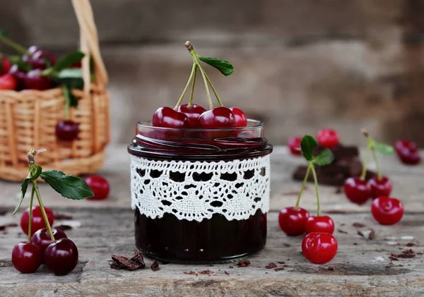 Confiture de cerises au chocolat dans un bocal en verre et cerises fraîches — Photo