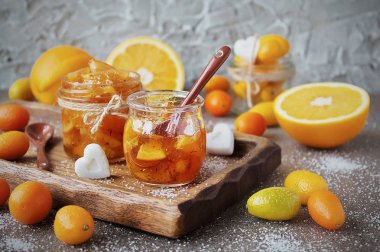 portakal bir cam kavanoz, taze turuncu ve gri granit zemin üzerine kumquats üzerinden ev yapımı reçel