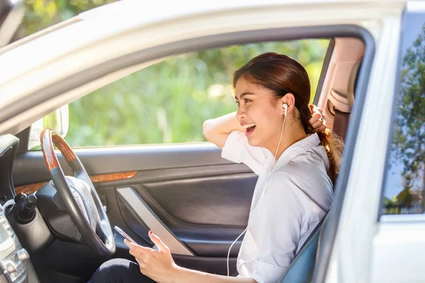 Primer plano retrato de feliz joven asiática mujer sentado en coche hablando en el teléfono celular — Foto de Stock