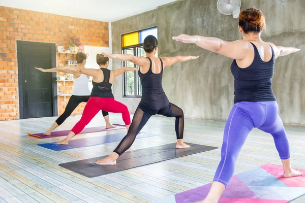 Fitness asiático femenino grupo haciendo calentamiento yoga pose en fila en la clase de yoga. enfoque selectivo —  Fotos de Stock