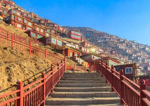 Larung가 르 (불교 아카데미) 햇볕에 배경에서 빨간 수도원은 푸른 하늘, 쓰촨 성, 중국 — 스톡 사진