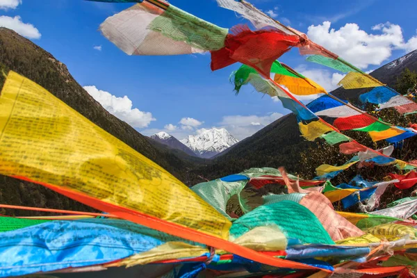 Montanha de neve na China Southwestern em Sertar County of Garze Prefeitura Autônoma Tibetana, no Tibete, Kham, China, com bandeiras de oração borradas em primeiro plano . — Fotografia de Stock