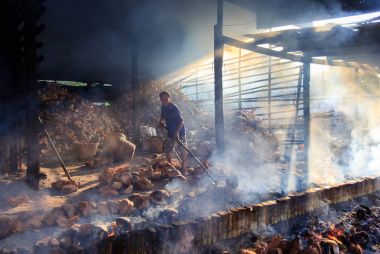 Chonburi - Nisan 19: bir adam hala yapmak tutmak için Hindistan cevizi kabuğu dolu malzemeler bambu tüplerini Yakılan Tay kültür içinde ve eski nesilden nesile yol Nisan'da 19,2014 içinde Chonburi, Thailand.