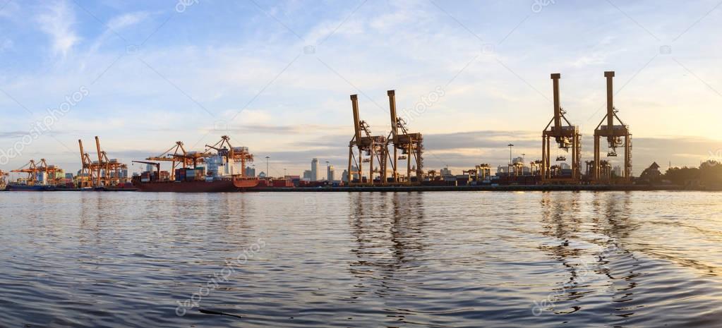 Panorama view working crane loading bridge in shipyard at sunrise time for Logistic Import Export background 