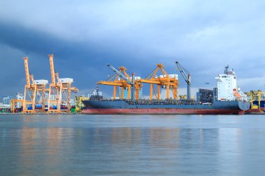 Konteyner kargo yük gemisi Tersanesi Köprüsü yükleme ve lojistik ithalat ihracat arka plan için alacakaranlıkta gün yağmur çalışma vinç ile