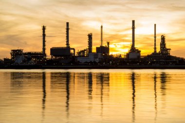 Petrol rafinerisi fabrika siluet ve gündoğumu gökyüzünde