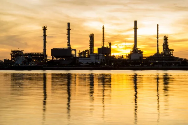 Olieraffinaderi fabrik i silhuet og solopgang himmel - Stock-foto