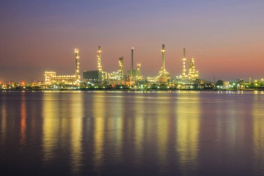 Petrol rafinerisi fabrika siluet ve gündoğumu gökyüzünde