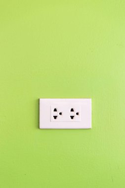 yeşil duvar üzerinde basit beyaz elektrik ABD soket