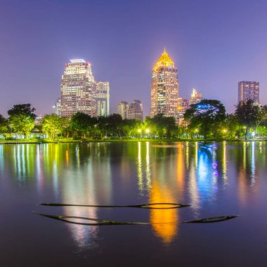 Bir park iş bölgesi cityscape günbatımı zaman Lumpini Park, Bangkok, Tayland