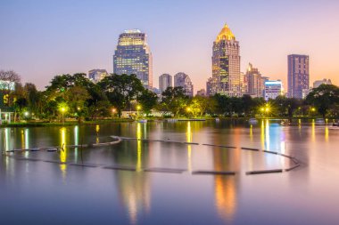 Bir park iş bölgesi cityscape günbatımı zaman Lumpini Park, Bangkok, Tayland