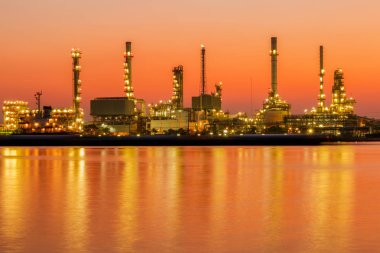 Petrol rafinerisi fabrika siluet ve gündoğumu gökyüzünde