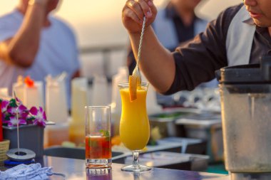 Çatı katındaki bar ve restoran sipariş müşteriler için mix portakal suyu hazırlama sürecinde barmenler kapatın.