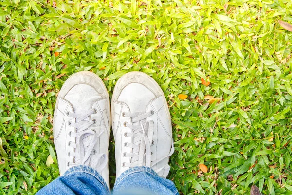 Gros plan de chaussures blanches en cuir debout sur l'herbe. Vue de dessus. Style de luminosité . — Photo