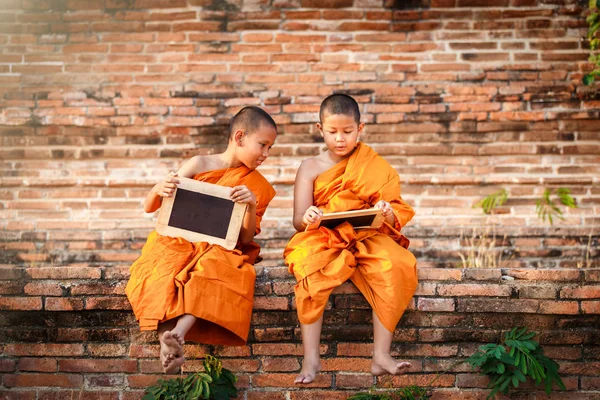 Dois novatos lendo e estudando quadro-negro com engraçado no antigo templo ao pôr do sol, Província de Ayutthaya, Tailândia — Fotografia de Stock