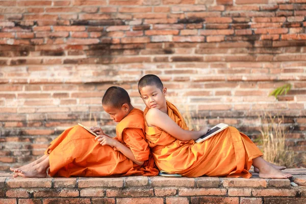 Dois novatos lendo e estudando quadro-negro com engraçado no antigo templo ao pôr do sol, Província de Ayutthaya, Tailândia — Fotografia de Stock