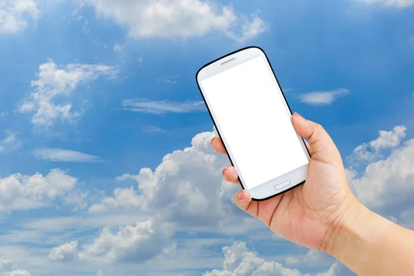 Hand holds smartphone with cut out screen and sky on background